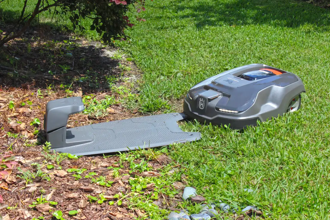 An Automower charging station installed at the edge of a landscape bed